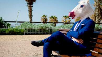 Un homme en costume avec un masque de licorne