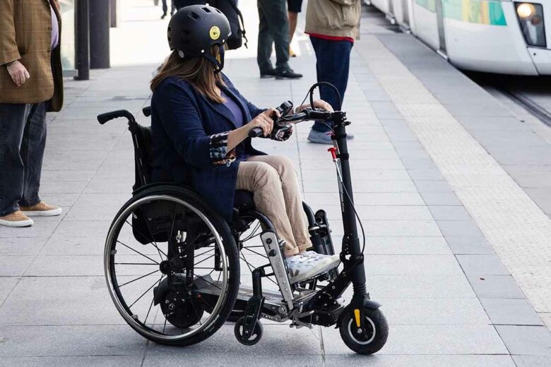Une trottinette électrique qui s'adapte à un fauteuil roulant.