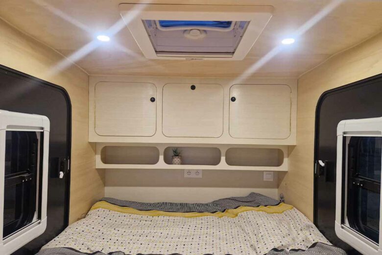 Un espace de couchage confortable et de nombreux rangements pour cette mini caravane.