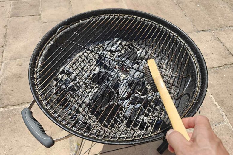 La brosse métallique facilite le nettoyage sur une grille de barbecue encore chaude.