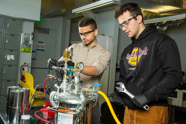 Ingénieurs du MIT travaillant sur un réacteur à hydrogène, conçu pour produire de l'hydrogène gazeux en mélangeant des pastilles d'aluminium avec de l'eau de mer.