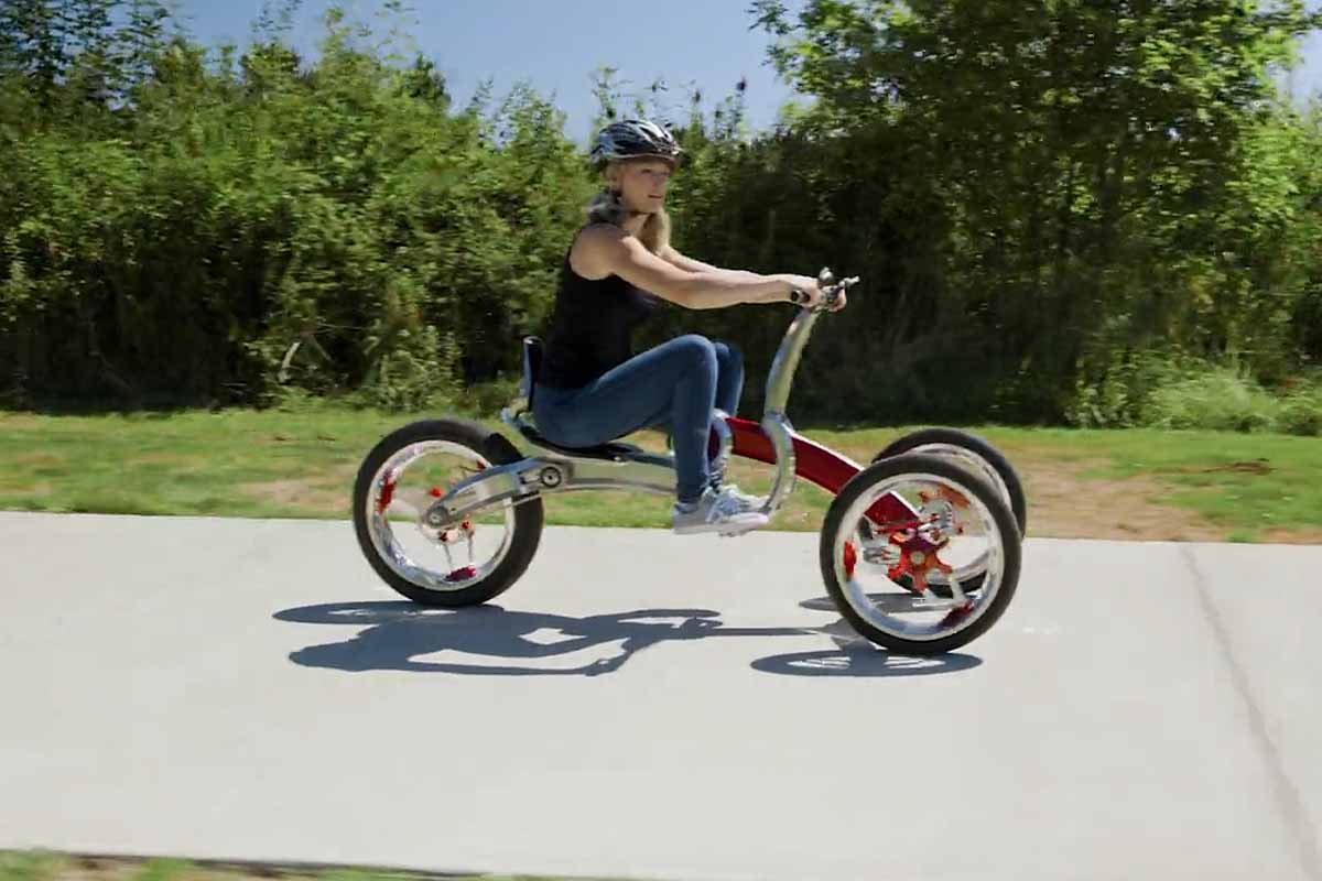 Un tricycle à assistance électrique ou l'on doit « pomper » avec ses bras et ses jambes pour avancer.