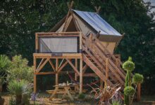 Une tente de camping montée sur une terrasse en bois.