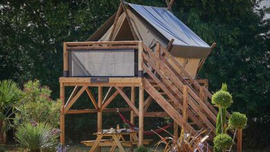 Une tente de camping montée sur une terrasse en bois.