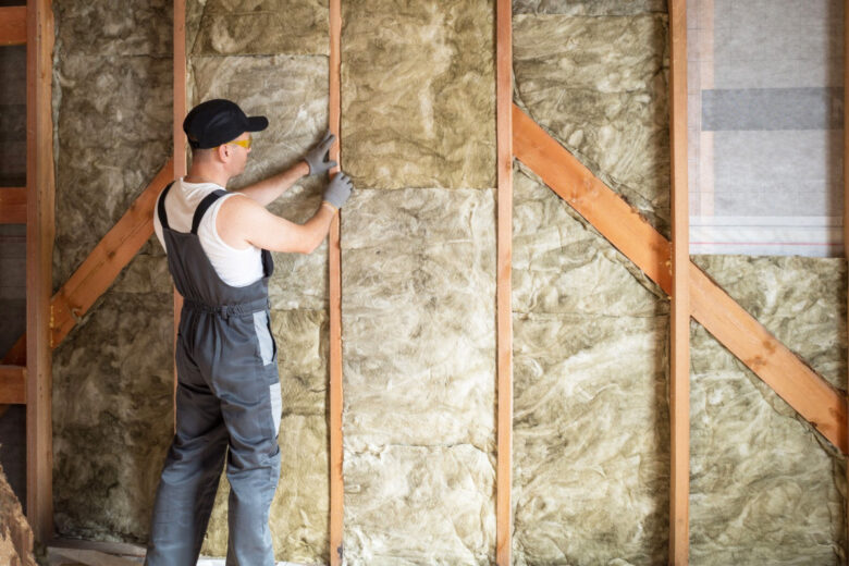 Un ouvrier qui réalise l'isolation des murs pour un confort thermique optimal.