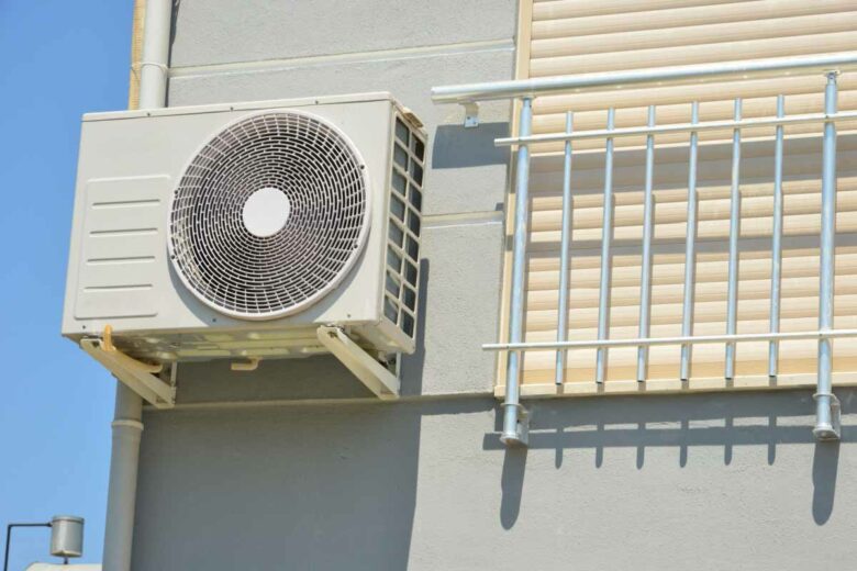 Une pompe à chaleur air-air pour chauffage et eau chaude sur la façade d'un immeuble résidentiel.