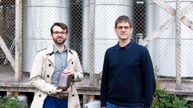 Les chercheurs de l'ETH Zurich Samuel Heiniger (à gauche, avec un bocal de minerai de fer) et le professeur Wendelin Stark devant les trois réacteurs à fer du campus Hönggerberg de l'ETH Zurich.