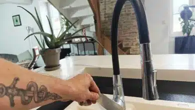 Un homme qui ouvre un robinet pour faire couler de l'eau.