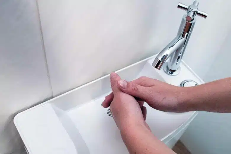 Le lavage de mains dans un lavabo.