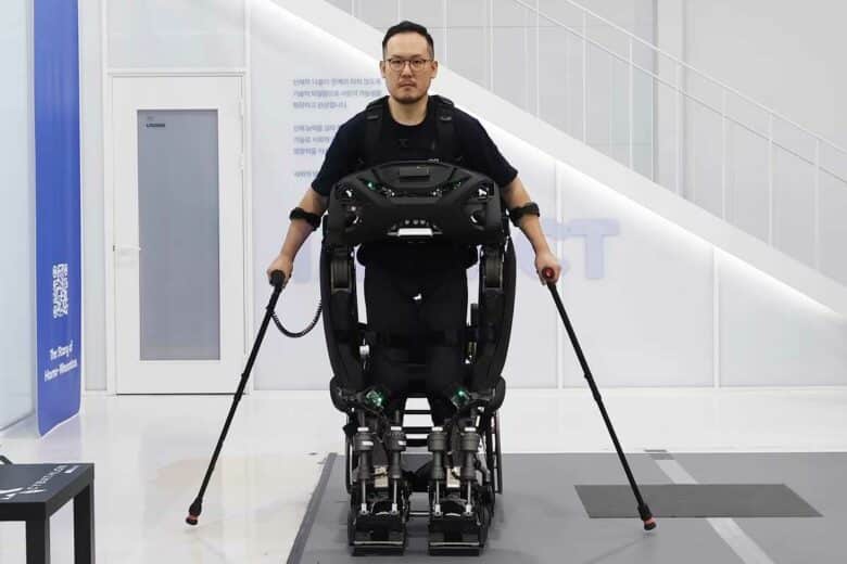 Un patient paraplégique se tient debout à l'aide d'un exosquelette.