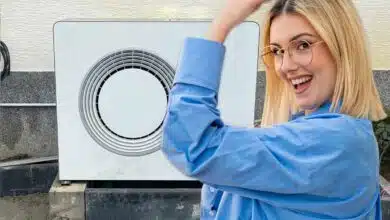 Une femme victorieuse devant une pompe à chaleur.