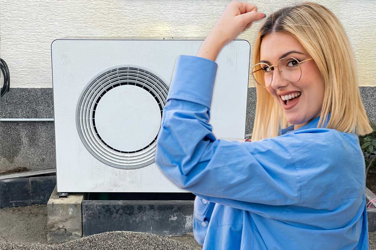 Une femme victorieuse devant une pompe à chaleur.