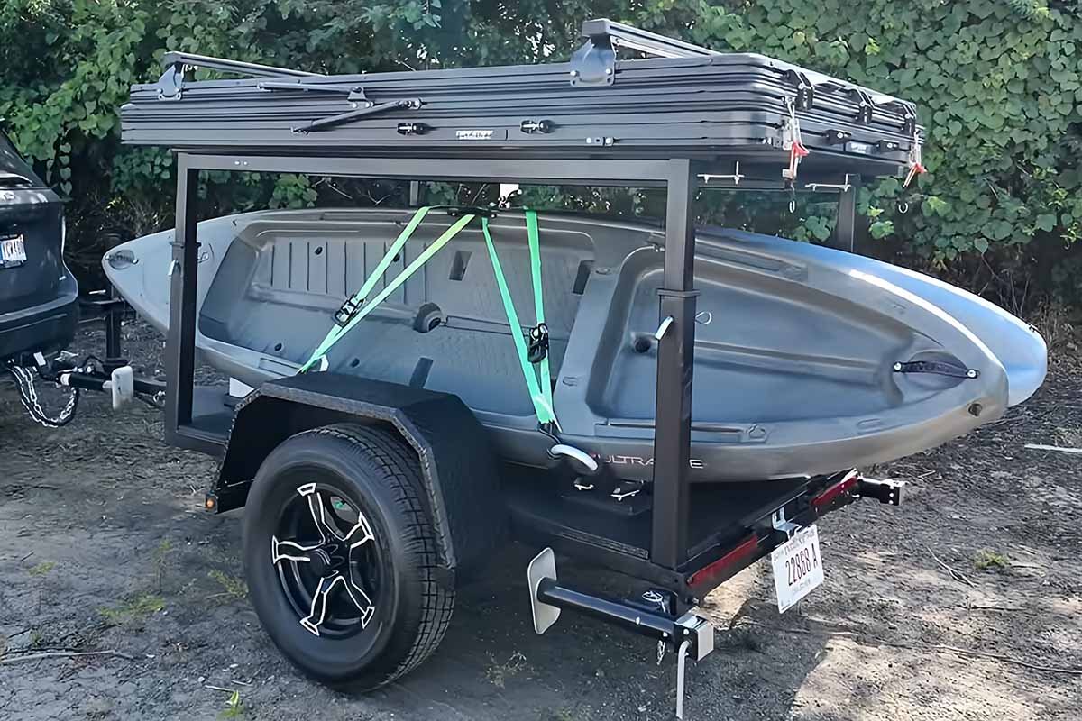 Une remorque modulable avec une tente de toit pour transporter des canoës et des kayaks.