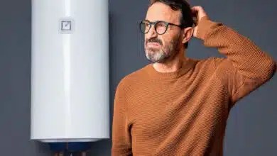 Un homme interrogatif face à un chauffe-eau.