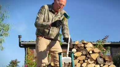 Un homme utilise un refendeur de buche.