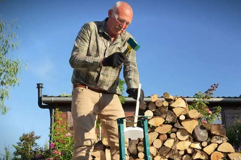 Un homme utilise un refendeur de buche.