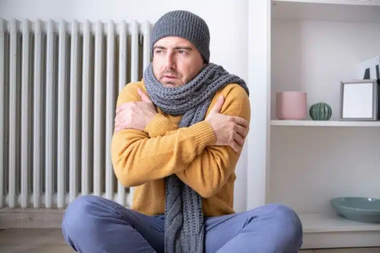 Un homme qui a froid dans un appartement.