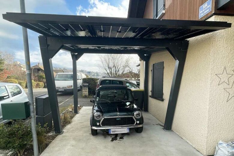 Un carport solaire installé contre une habitation.