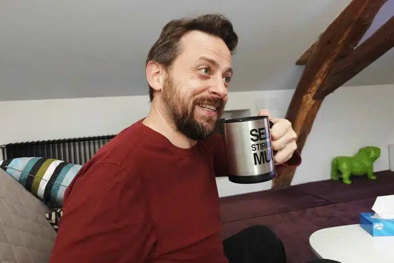 Un homme qui boit un café dans un mug.