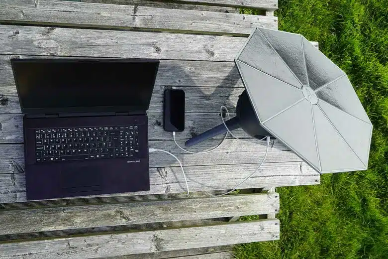 Une station solaire charge un ordinateur et un téléphone.