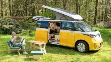 Un couple se détend dans la nature à côté de leur van aménagé.