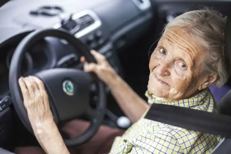 Une femme âgée derrière un volant.