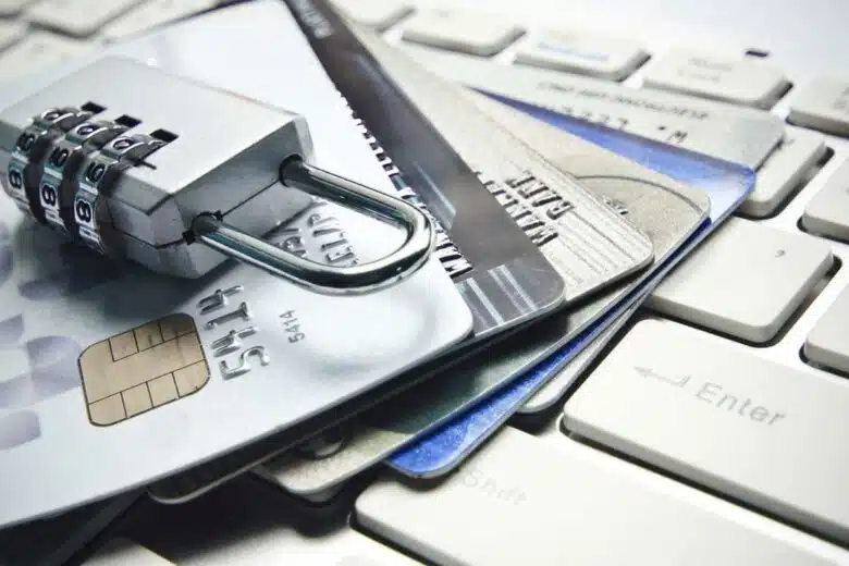 Un cadenas sur des cartes bancaires posées sur un clavier d'ordinateur.