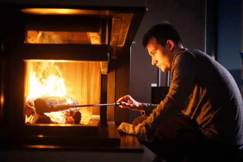 Un homme devant le feu d'une cheminée.