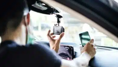 Un homme installe une dashcam dans un véhicule.