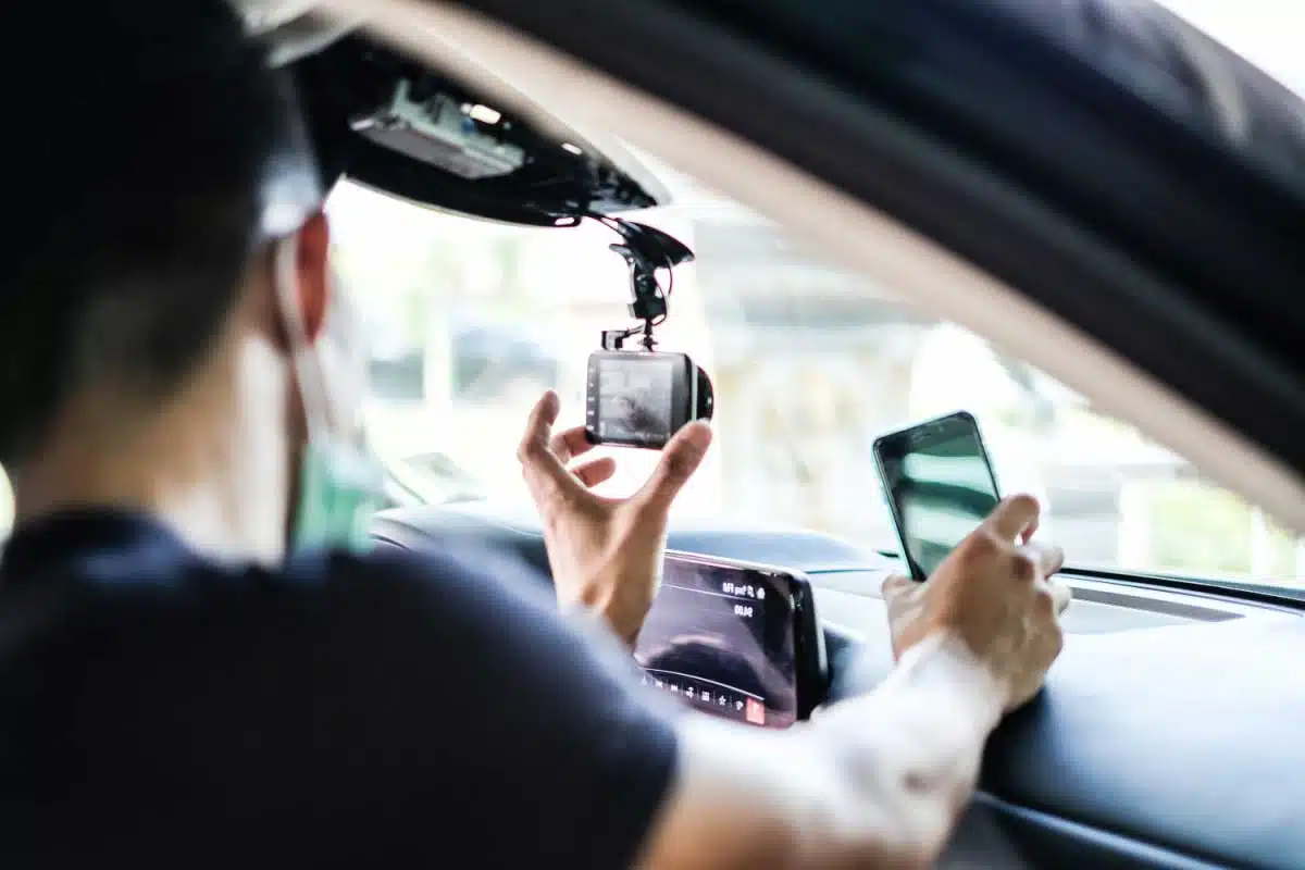 Un homme installe une dashcam dans un véhicule.