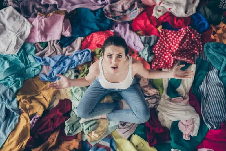 Une femme sur un tas de vêtements en désordre.