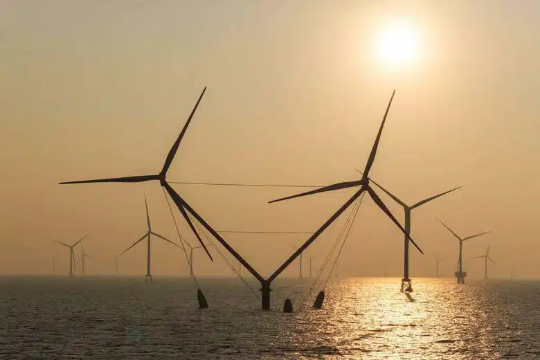 L'éolienne OceanX sur l'eau avec un coucher de soleil.