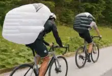 Un cycliste qui porte un sac à dos gonflable.