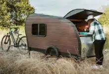 Une mini-caravane tractée par un vélo.