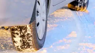 Une voiture circule sur une route enneigée.