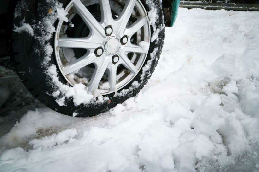 Une voiture roule dans la neige.