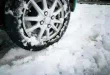 Une voiture roule dans la neige.