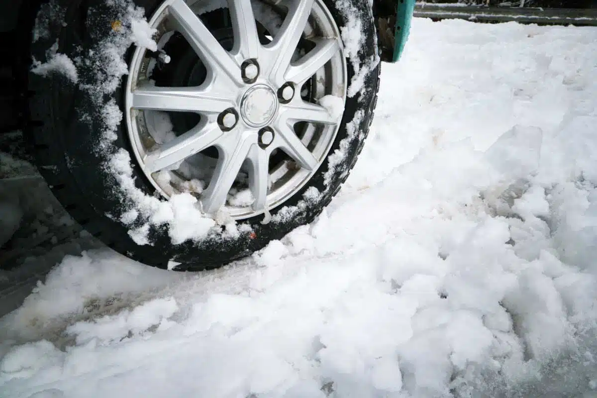 Une voiture roule dans la neige.