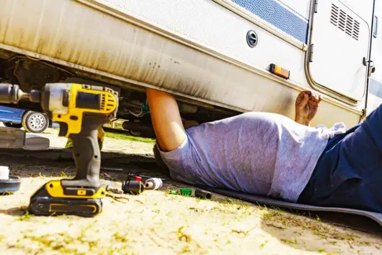 Une personne répare une caravane.