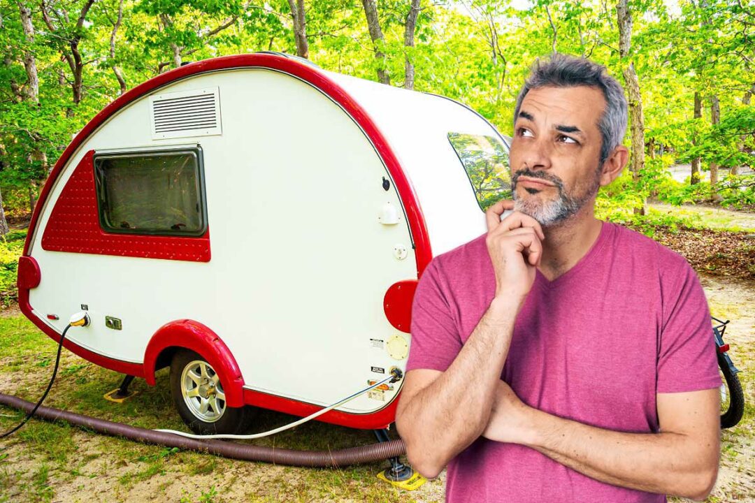 Un homme sceptique devant une mini caravane.