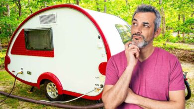 Un homme sceptique devant une mini caravane.