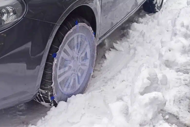 Une voiture roule sur la neige avec un équipement textile.