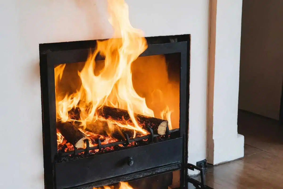 Des flammes sortent du foyer de la cheminée.