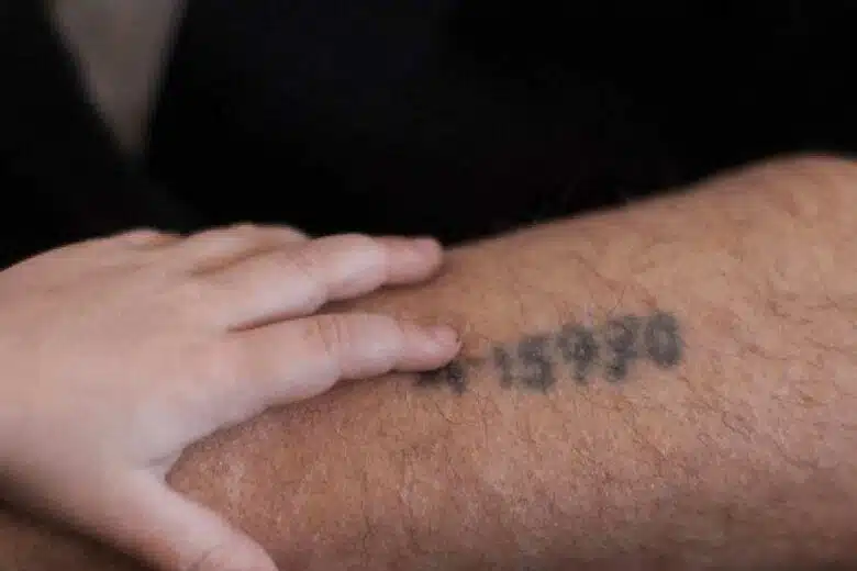 Une main d'enfant sur le bras tatoué d'un rescapé de la Shoah.