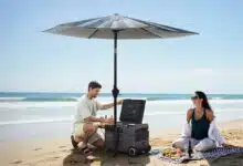 Un couple sur la plage sous un parasol avec une glacière.