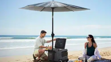 Un couple sur la plage sous un parasol avec une glacière.