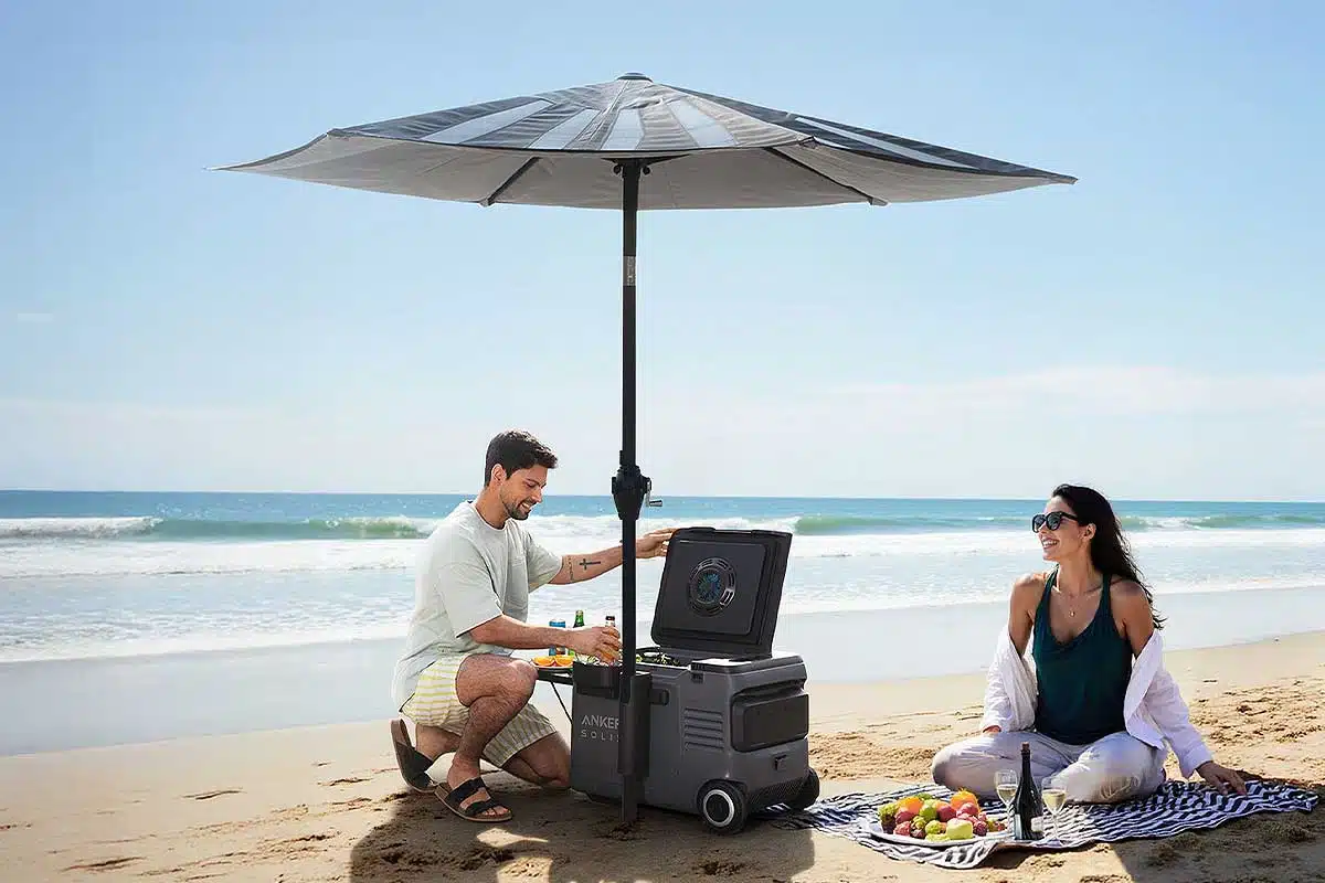 Un couple sur la plage sous un parasol avec une glacière.