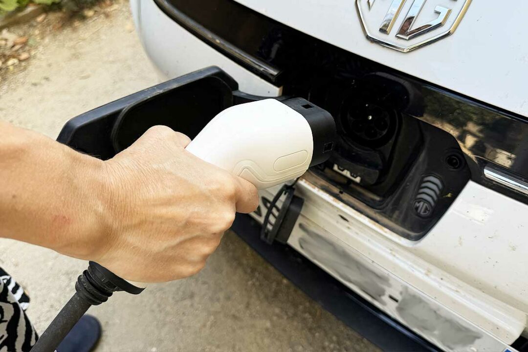 Une personne va recharger son véhicule électrique.