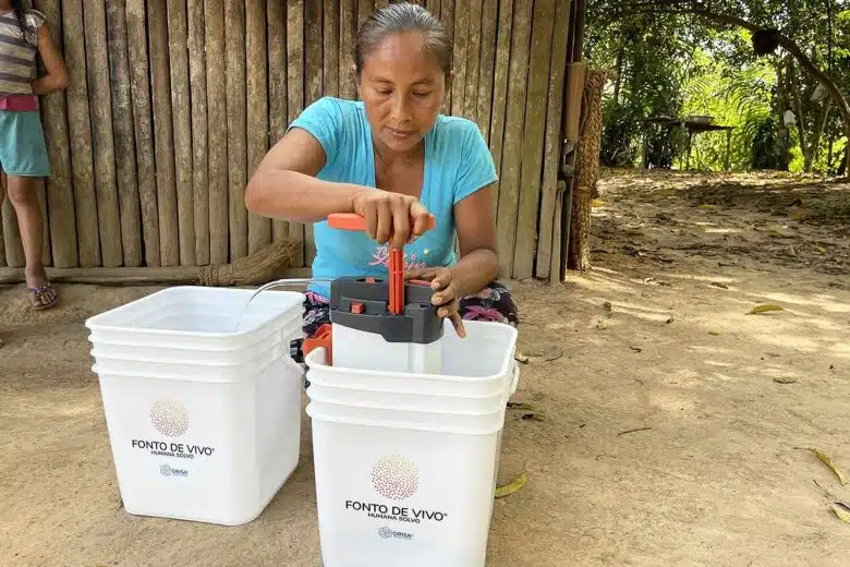 Une femme utilisant ORISA pour avoir de l'eau potable.