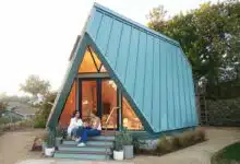 Une maison en A Polyhaus avec un couple sur le porche.